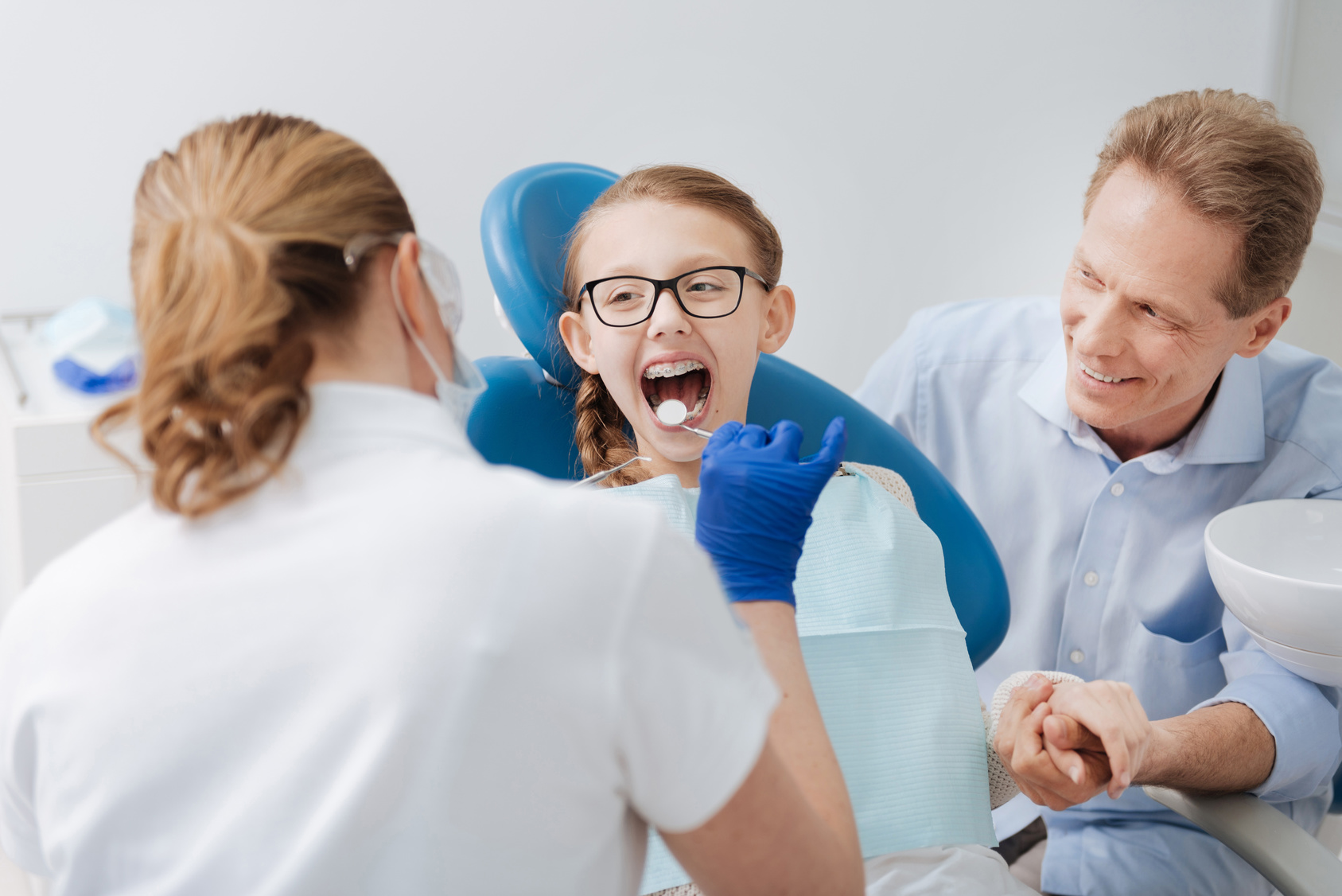 Adorable Positive Girl Visiting Dentist with Her Dad why choosing a family dentist with cosmetic expertise matters